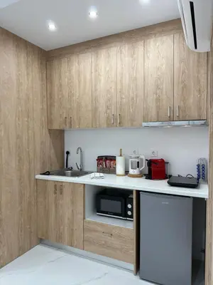 a kitchen with wooden cabinets and a sink and a microwave at Stylish Athens Base near Acropolis & Metro in Athens