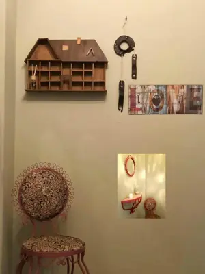 a room with a chair and a model house on the wall at Froso's fresh old apartment in Gazi in Athens