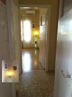 a room with a hallway with a door and a window at Froso's fresh old apartment in Gazi in Athens