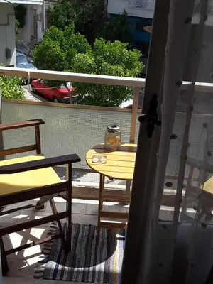 a yellow table and chairs on a balcony at Froso's fresh old apartment in Gazi in Athens