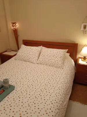 a bed with polka dot sheets and pillows in a bedroom at Froso's fresh old apartment in Gazi in Athens
