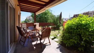 a patio with a table and chairs on a balcony at Michael Apartment, near the Airport in Koropíon