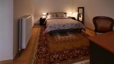 a bedroom with a bed and a large rug at Michael Apartment, near the Airport in Koropíon