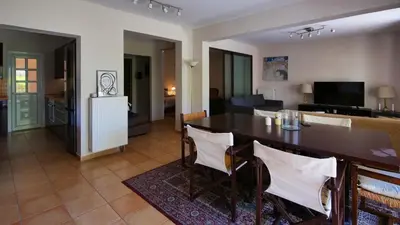 a dining room and living room with a table and chairs at Michael Apartment, near the Airport in Koropíon