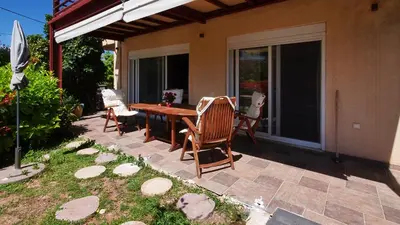 a patio with a wooden table and chairs at Michael Apartment, near the Airport in Koropíon