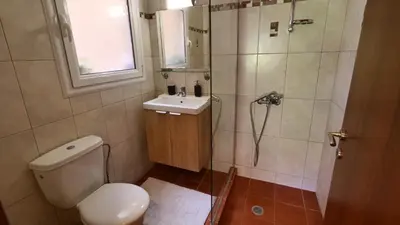 a bathroom with a shower and a toilet and a sink at Michael Apartment, near the Airport in Koropíon