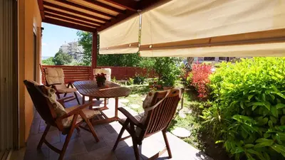 a patio with a table and chairs and an umbrella at Michael Apartment, near the Airport in Koropíon