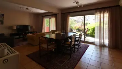 a living room with a dining room table and a couch at Michael Apartment, near the Airport in Koropíon