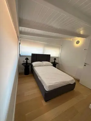 a bedroom with a bed in a white room at Penthouse with sea view in Athens