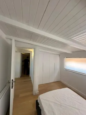 a white room with a bed and a hallway at Penthouse with sea view in Athens