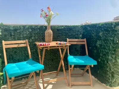 two chairs and a table with a vase on it at Roof Garden Home in Athens