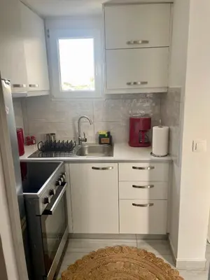 a small kitchen with white cabinets and a sink at Roof Garden Home in Athens