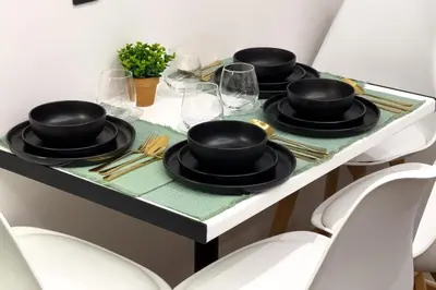 a table with black plates and glasses on it at The Athens Getaway Apartment GF in Athens