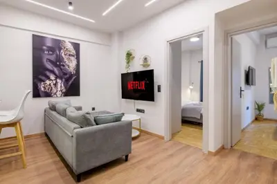 a living room with a couch and a tv at The Athens Getaway Apartment GF in Athens