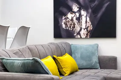 a living room with a couch with yellow and green pillows at The Athens Getaway Apartment GF in Athens