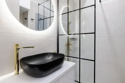 a bathroom with a black sink and a mirror at The Athens Getaway Apartment GF in Athens
