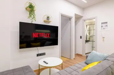 a living room with a couch and a tv on a wall at The Athens Getaway Apartment GF in Athens