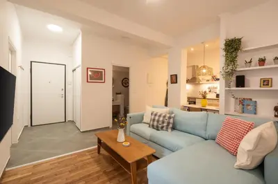 a living room with a blue couch and a table at 1BR Next to Metro Modern Comfort in Athens
