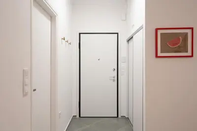 a hallway with white doors and a mirror at 1BR Next to Metro Modern Comfort in Athens