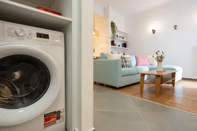 a washing machine in a living room with a couch at 1BR Next to Metro Modern Comfort in Athens