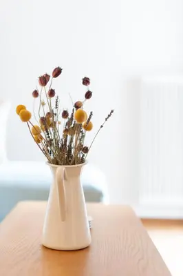 a white vase with flowers sitting on a table at 1BR Next to Metro Modern Comfort in Athens