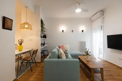 a living room with a blue couch and a table at 1BR Next to Metro Modern Comfort in Athens