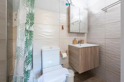 a bathroom with a toilet and a sink and a mirror at Cozy home in the heart of Athens in Athens