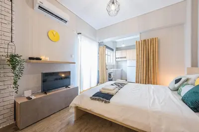 a bedroom with a large bed and a flat screen tv at Cozy home in the heart of Athens in Athens