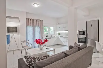 a living room with a couch and a kitchen at Serenity in the city - Stylish 1bd Garden Flat in Athens