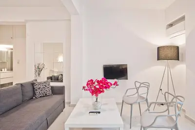 a living room with a couch and a table with flowers at Serenity in the city - Stylish 1bd Garden Flat in Athens