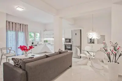 a white living room with a couch and a table at Serenity in the city - Stylish 1bd Garden Flat in Athens