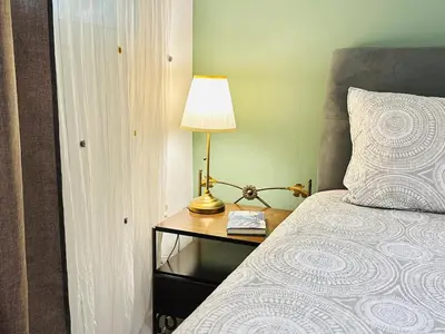 a bedroom with a bed with a lamp on a night stand at Zoy's house in Athens