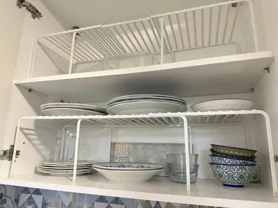 a white shelf with plates and bowls on it at Zoy's house in Athens