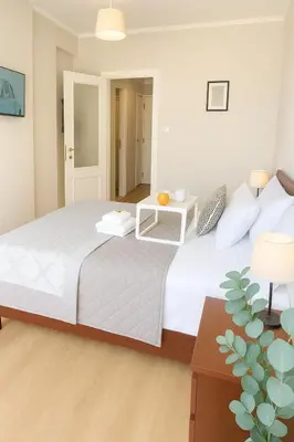 a bedroom with a large white bed and a table at Saronida BEACH STUDIO in Saronida