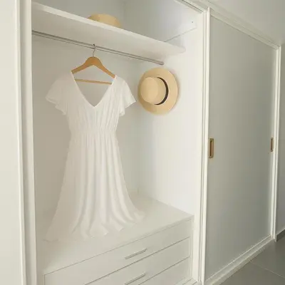 a white dress is hanging in a white closet at Saronida BEACH STUDIO in Saronida