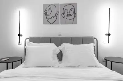 a bedroom with a bed with two paintings on the wall at Stylish & Bright Flat Across Metro - 8' to Center in Athens