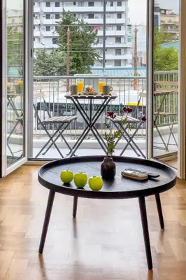 a table with apples on it in front of a balcony at Stylish & Bright Flat Across Metro - 8' to Center in Athens