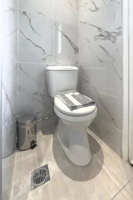 a bathroom with a toilet with a black and white seat at Stylish & Bright Flat Across Metro - 8' to Center in Athens