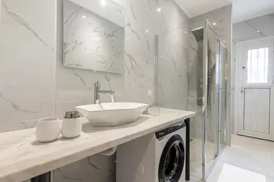 a bathroom with a sink and a washing machine at Stylish & Bright Flat Across Metro - 8' to Center in Athens