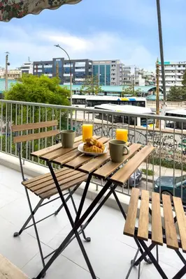 a table with a plate of food on a balcony at Stylish & Bright Flat Across Metro - 8' to Center in Athens