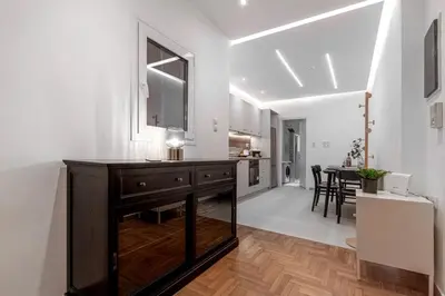 a kitchen and living room with white walls and wood floors at Stylish & Bright Flat Across Metro - 8' to Center in Athens