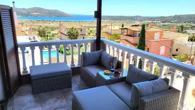 a balcony with two couches and a view of the ocean at Villa Golden Sun with swimming pool and jacuzzi in Anavissos
