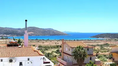a view of a town with a church and the ocean at Villa Golden Sun with swimming pool and jacuzzi in Anavissos