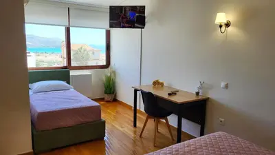 a room with two beds and a desk with a desk at Villa Golden Sun with swimming pool and jacuzzi in Anavissos
