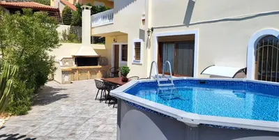 a swimming pool in front of a house at Villa Golden Sun with swimming pool and jacuzzi in Anavissos