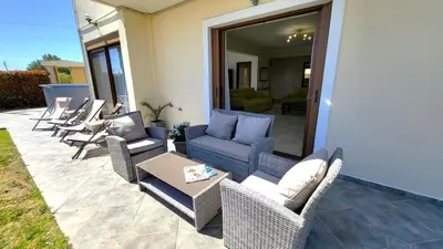 a patio with wicker chairs and a table at Villa Golden Sun with swimming pool and jacuzzi in Anavissos