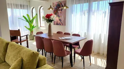 a dining room with a table and chairs and a couch at Villa Golden Sun with swimming pool and jacuzzi in Anavissos