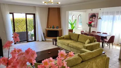 a living room with two couches and a dining room at Villa Golden Sun with swimming pool and jacuzzi in Anavissos