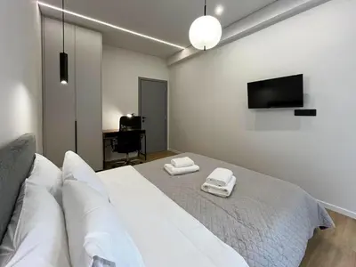 a bedroom with a bed with two white towels on it at 3BR Modern & Spacious apt in Athens