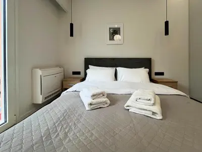 a bedroom with a bed with towels on it at 3BR Modern & Spacious apt in Athens